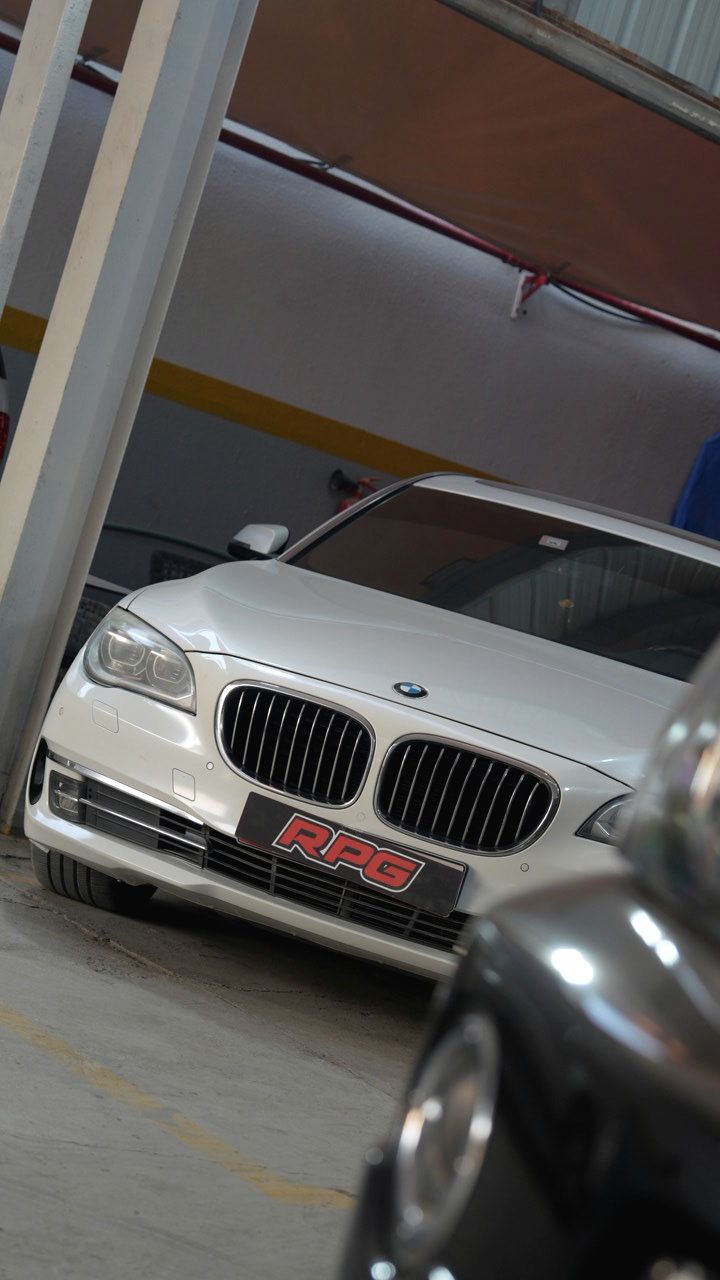 White BMW 7 Series with an RPG plate inside the workshop