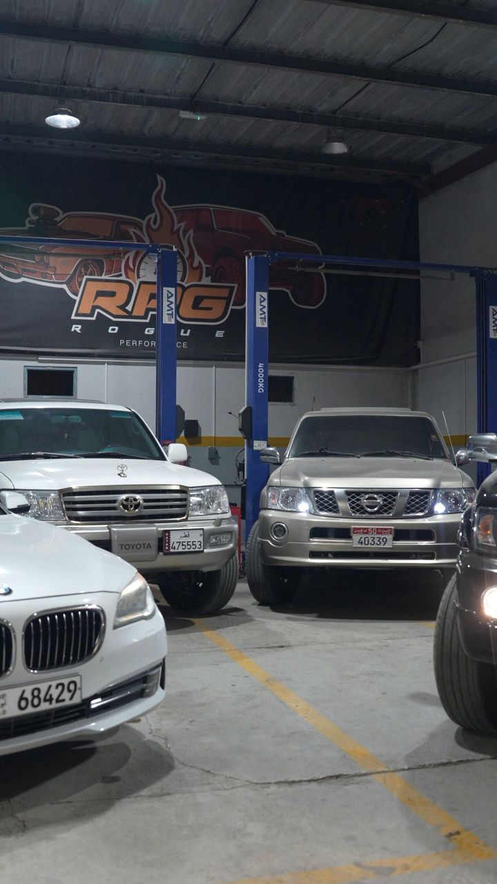Row of 4x4s and sedans parked in the workshop at night