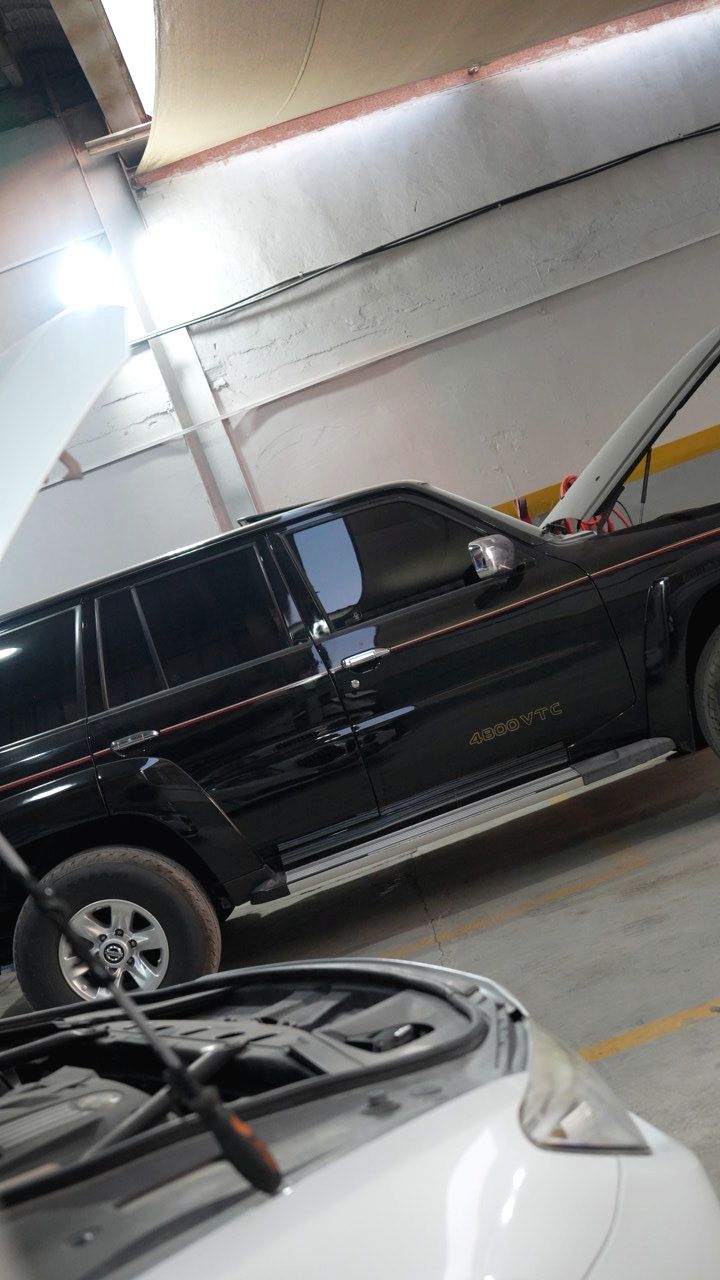 Black Nissan Patrol 4800 VTC parked inside the workshop
